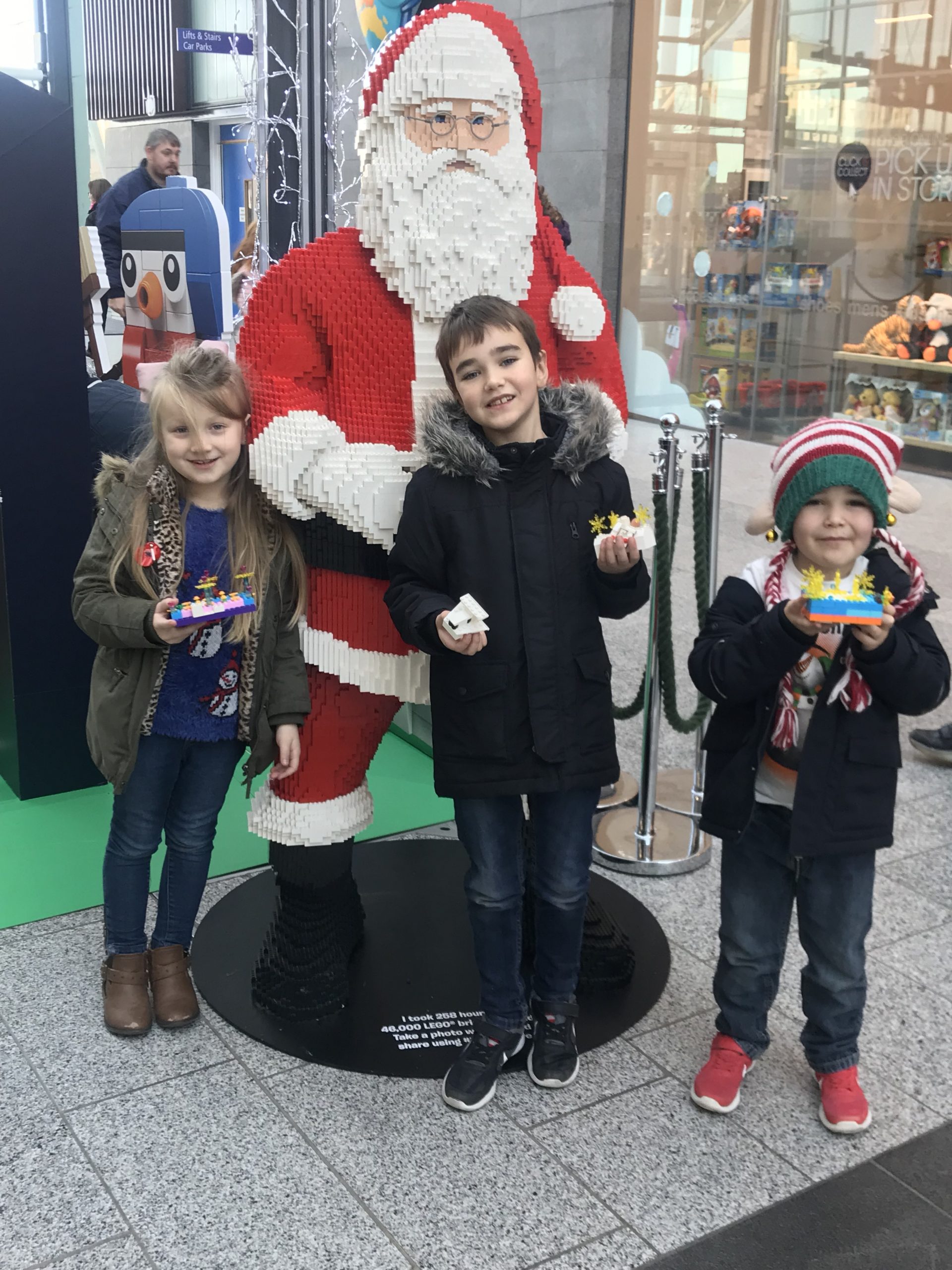 Children posing for a photo with a Lego Father Christmas