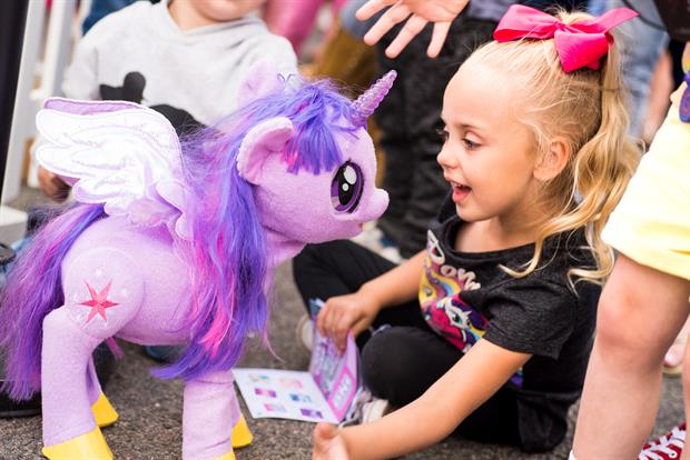 Child with purple my little pony soft toy