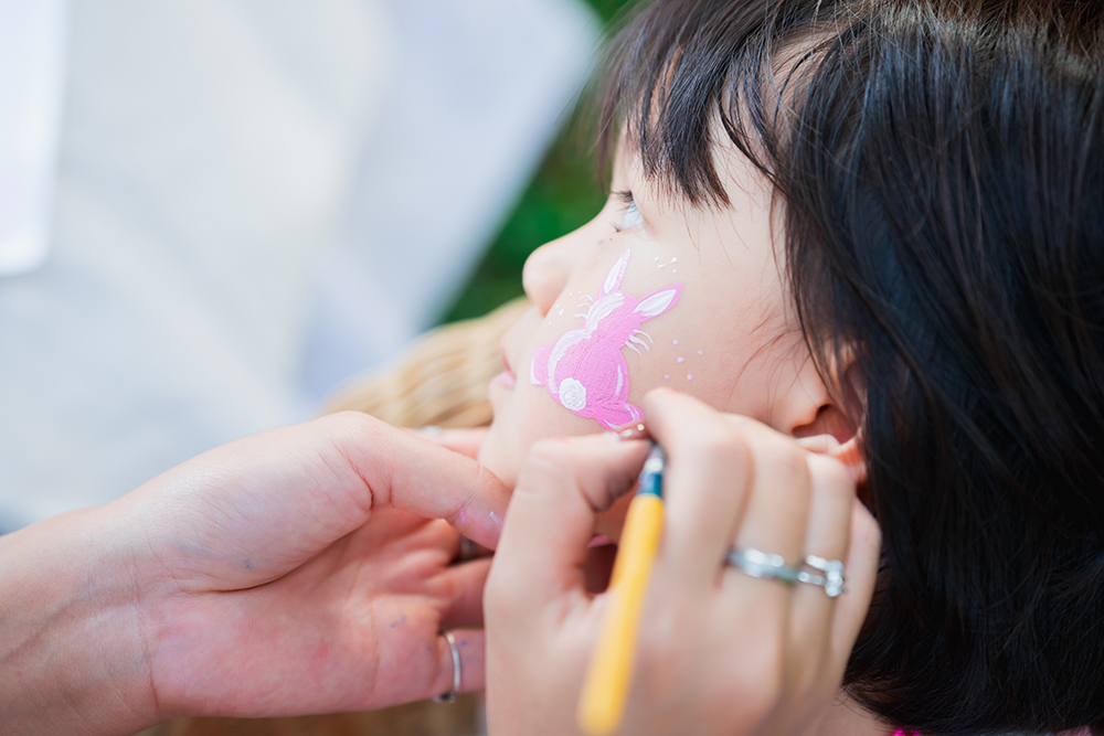 Pink easter bunny being painted on a child's face